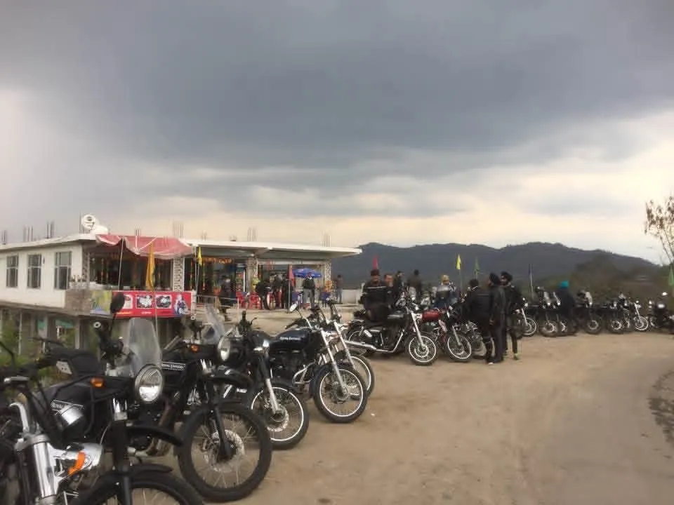 Motorcycles parked in a row outside a roadside café under dark storm clouds