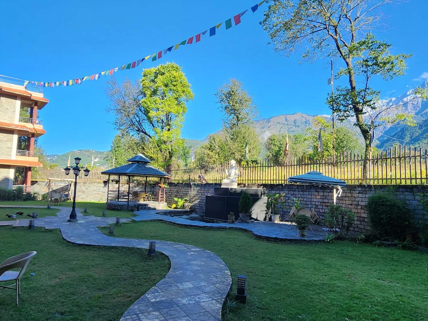 The Quartz garden with a gazebo, lawns and prayer flags under a blue sky