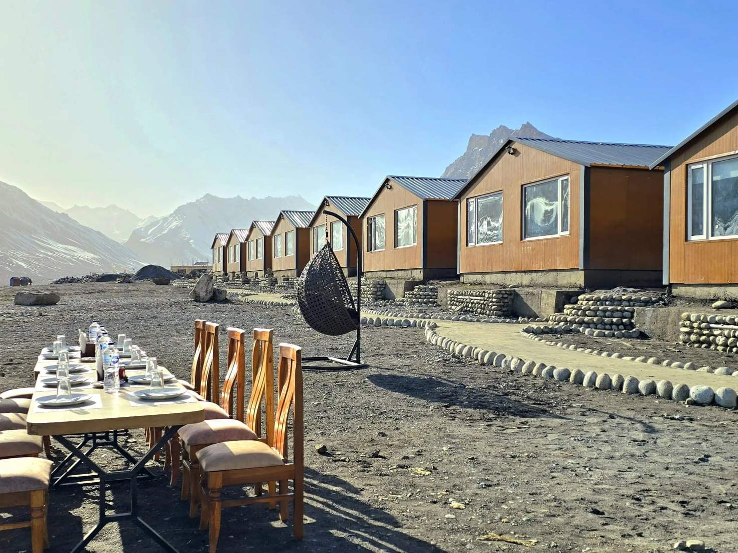 A long table laid outdoors beside the Spiti Villa cottages